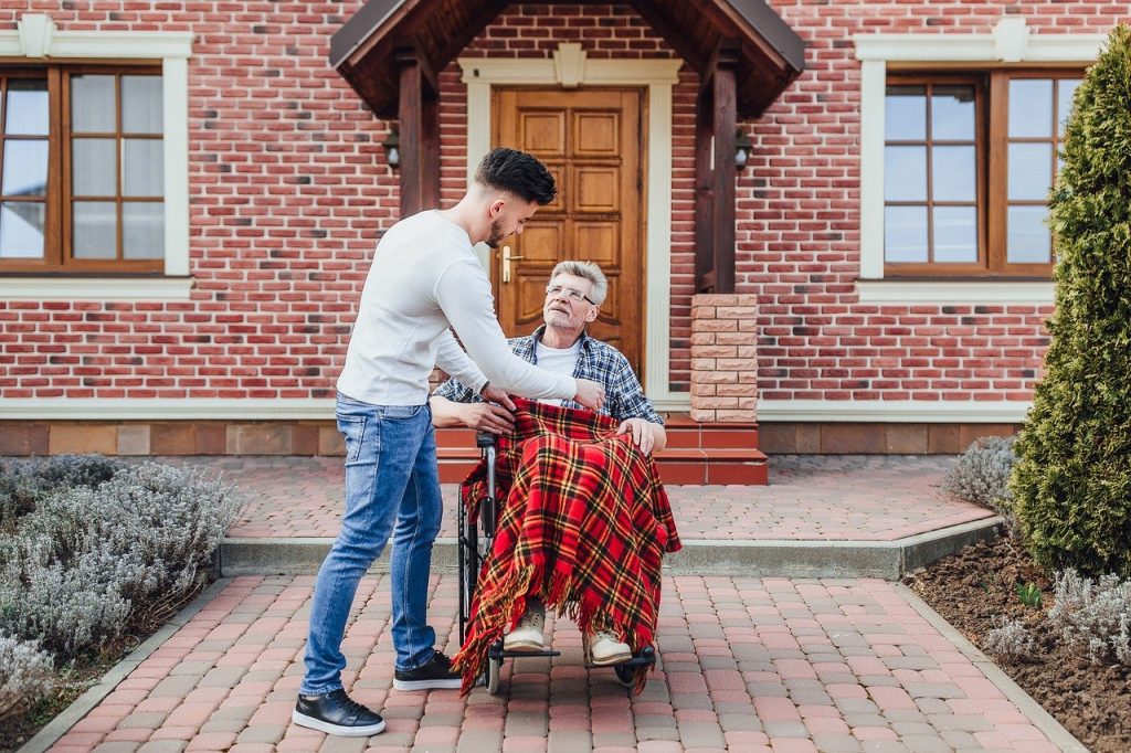Man assisting elderly in wheelchair